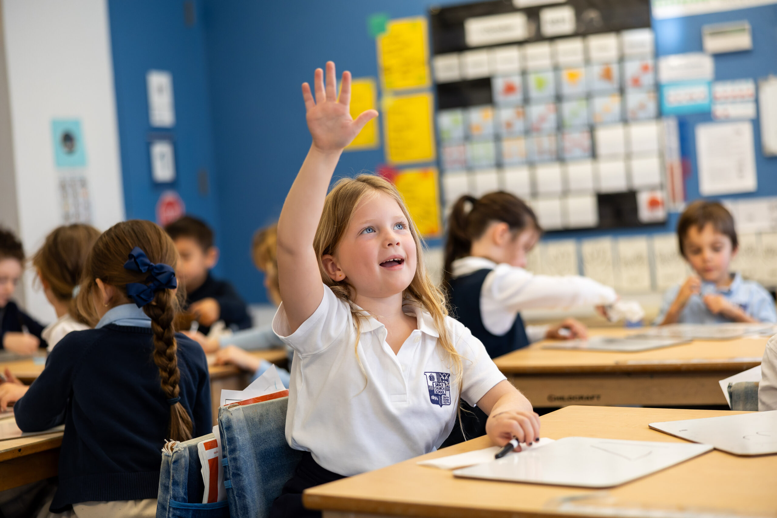 Early childhood student enthusiastically raising her hand. 