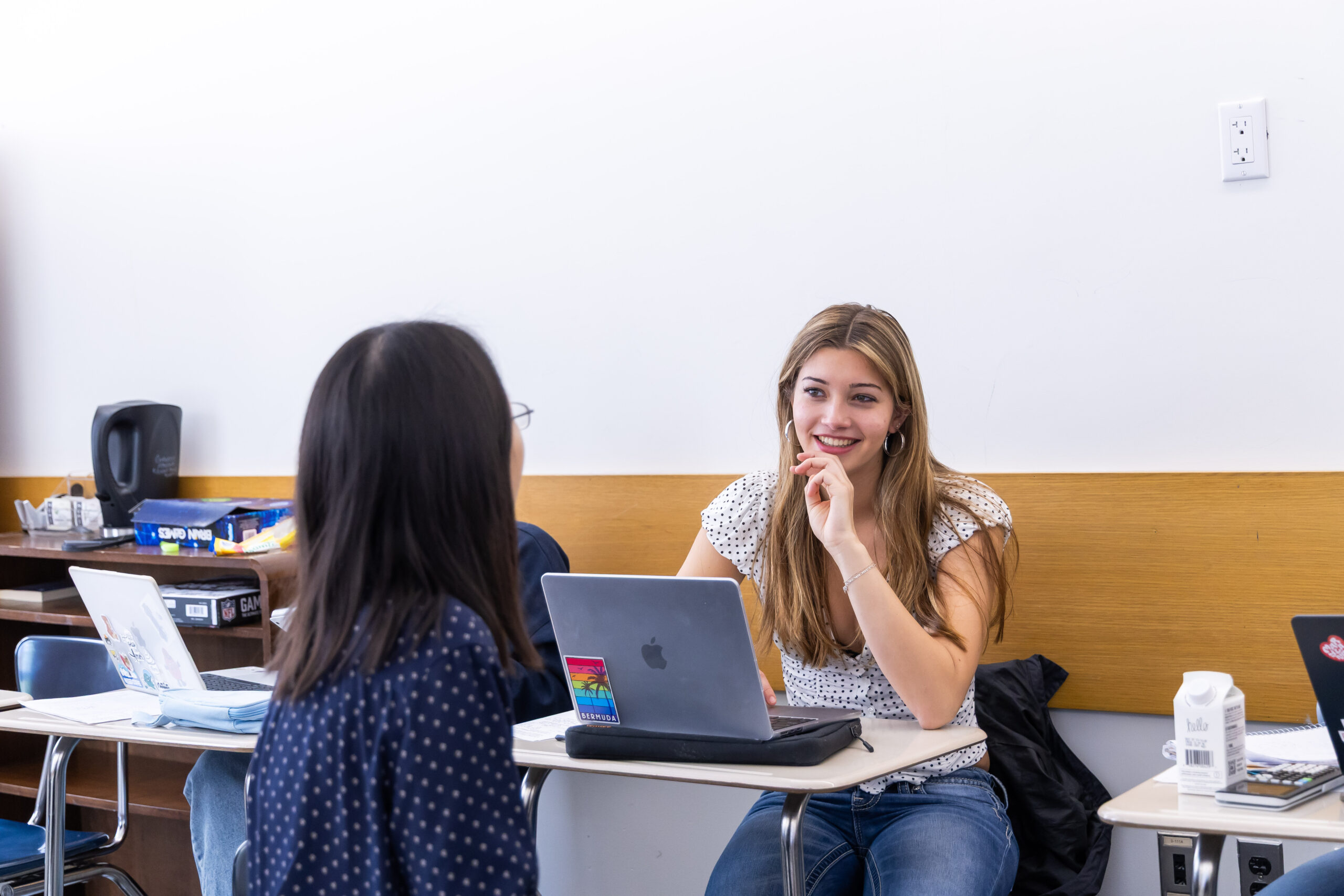 Students and a teacher are around a table talking together