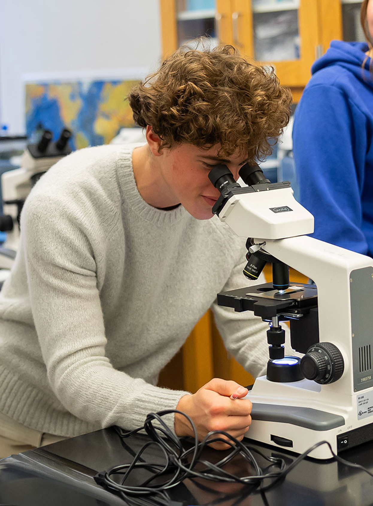High School student looking through a microscope